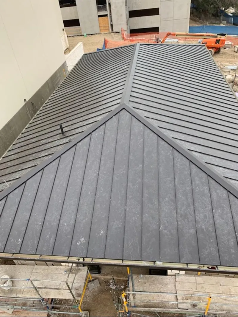 Commercial metal roof construction with crane equipment in Grandview